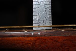 Figure 1.  Measuring the string height from the top of the 12th fret to the bottom of the low-E string.