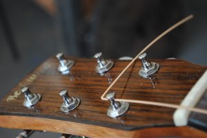 Figure 6. Turn the string towards the center of the headstock. On the bass strings, this is to the right, the treble strings go to the left.