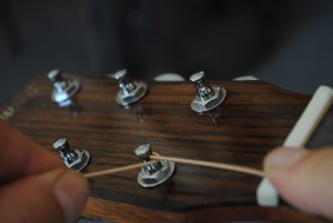 Figure 7. Take the excess string under the rest of the string where it enters the tuning post hole.